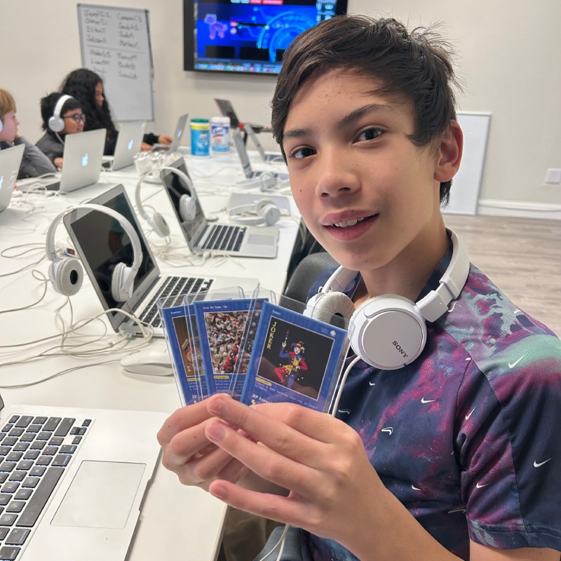 A Hackingtons Brentwood student showing the achievement cards he earned in class