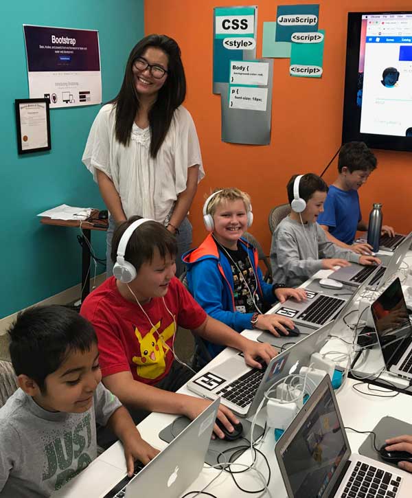 An instructor with a row of students coding at Hackingtons Pleasant Hill